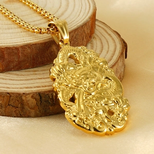 Macro shot of 18K gold plated double-sided dragon pendant with detailed dragon carving