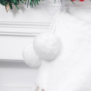 Detailed view of white faux rabbit fur Christmas stocking with fluffy pom-poms