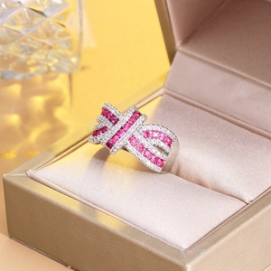 Detailed macro shot of a criss-cross bow ring featuring pink and white gemstones on silk