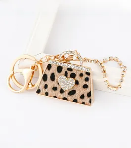 Close-up of leopard print handbag keychain with sparkling rhinestones and golden hardware