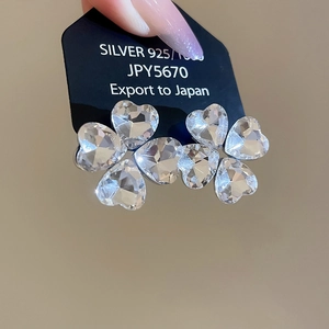 Close-up of heart-shaped crystal stud earrings made of 925 silver on a black display card