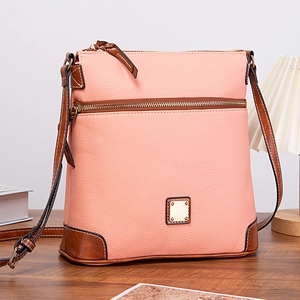 Close-up of pink and brown crossbody bag with lychee texture and metal plaque detail