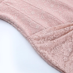 Close-up of pink floral lace fabric with delicate embroidery on the backless dress