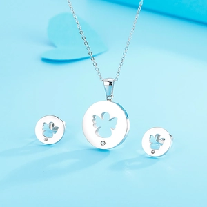 Close-up of silver angel wing pendant and earrings set on soft blue background