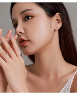 Detail showing elegant snowflake ring and stud earring set with pavé stones on model