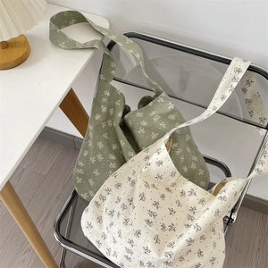 Detailed close-up of floral canvas tote bags in beige and green on a chair