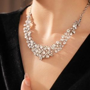 Detail of luxury geometric necklace with sparkling crystals worn by a model in black