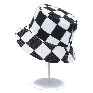 Detail of a black and white checkered bucket hat on a white metal display stand