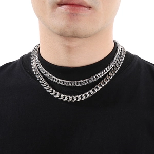 Close-up of double layered silver cuban link chain necklace on model neck in studio