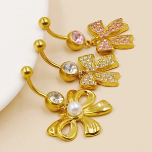 Three gold stainless steel navel rings with bow pendants featuring pink, clear crystals and pearl