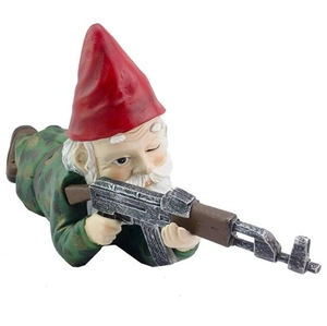Macro shot of a resin garden gnome in camo gear holding a realistic black tactical rifle