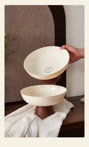 Detail of pedestal fruit bowl with wood grain base and diamond pattern drainage bowl