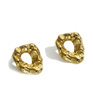 Modern irregular gold hoop earrings with hammer textured molten surface design