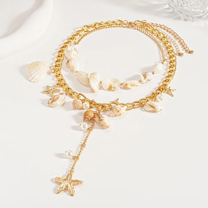 Detail of layered gold seaside necklace featuring shell, starfish, and pearl charms