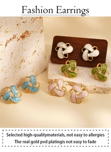 Detail of vintage flower knot earrings in white, pink, blue, and dark green enamel