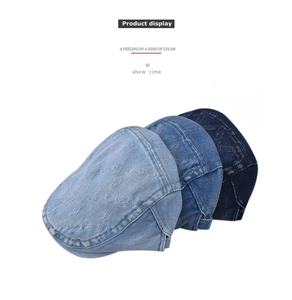 Flat lay of denim newsboy caps in dark, medium, and light blue with stitched patterns