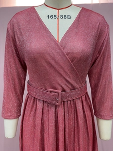 Détail de la robe plissée rouge rose scintillante avec col en V profond et ceinture assortie