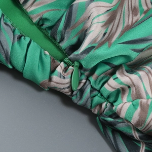 Detail of tropical leaf print fabric featuring a high-quality hidden green zipper closure