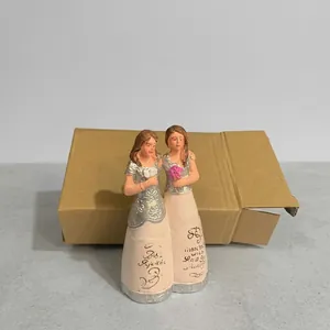 Detailed view of friendship figurine with floral dress and pink bouquet resin craft