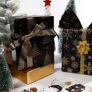Christmas gift wrapping paper with black and gold snowflake patterns and holiday trees