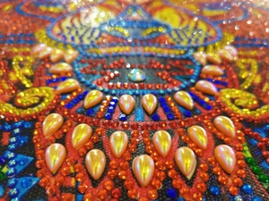 Macro shot of 5D DIY diamond painting kit featuring shiny resin drills and colorful gems