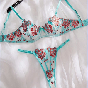 Flat lay of teal lace lingerie set featuring vibrant orange floral embroidery detailing