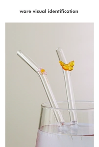 Detail of glass straws with handcrafted pink flower and yellow butterfly decorations