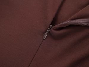 Close-up of a zipper on a dark brown slim-fit sports top with fine knit texture