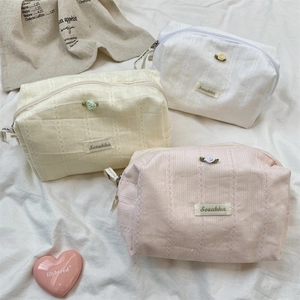 Three elegant rose pattern cosmetic bags in white, cream, and pink with soft lace texture