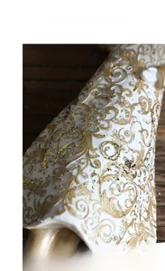 Dettaglio dei motivi dorati a rilievo su una statuina di coniglio in resina bianca