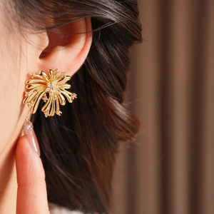 Gros plan d'une boucle d'oreille en forme de feu d'artifice avec zircons sur le mannequin