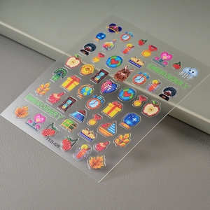 Detail of 3D embroidery style nail stickers with apple and clock patterns