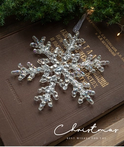 Close-up of iridescent acrylic snowflake ornament with rainbow glow on vintage book