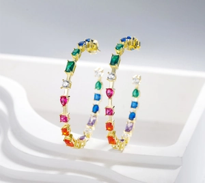 Macro shot of large gold hoop earrings with multi-colored crystals and vibrant zircon gems
