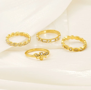 Detail of 4-piece gold bee and twisted ring set with sparkling zircon on satin back