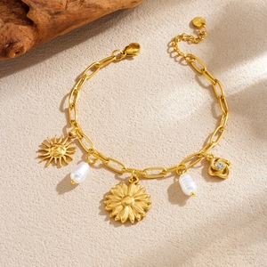 Bracelet en acier doré avec pendentifs fleur et visage de soleil et perles baroques