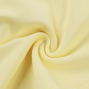 Macro shot of light yellow ribbed knit fabric texture showing high-quality material details