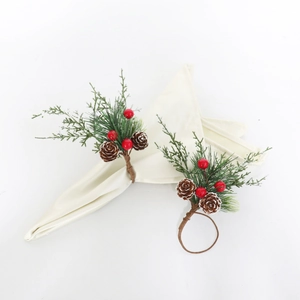 Gros plan d'un rond de serviette de Noël avec aiguilles de pin, baies rouges et pommes de pin