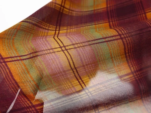 Gros plan sur le tissu à carreaux de la jupe avec texture sergé bordeaux et jaune