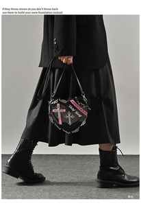 Gothic heart-shaped crossbody bag with pink crosses and silver chain details on model