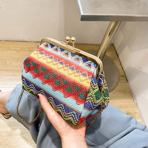 Close-up of colorful woven crossbody bag with geometric patterns and gold chain strap
