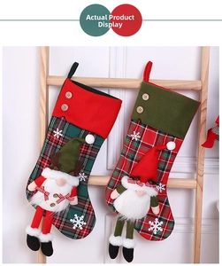 Close-up of red and green plaid Christmas stockings with 3D gnome dolls and buttons