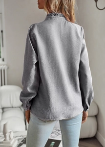 Vue arrière d'un haut gris texturé à manches longues pour femmes avec un col montant