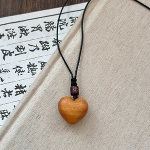Handcrafted wooden heart pendant necklace with black woven rope and Zen aesthetic