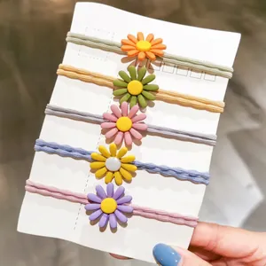 5-piece set of colorful daisy elastic hair ties in orange, green, pink, yellow, and purple