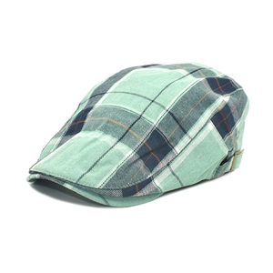 Detail view of the side metal adjustment buckle on the green plaid ivy cap