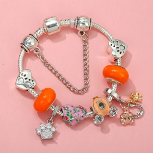 Detail of silver snake chain bracelet featuring orange glass beads and paw print charms