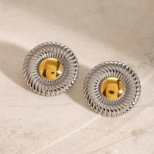 Close-up of two-tone stainless steel stud earrings with spiral texture and gold center