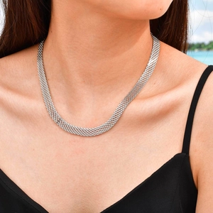 Detail of silver multilayer mesh necklace with woven metal texture worn by a model