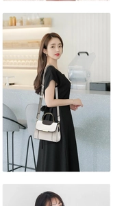 Détail d'un sac à bandoulière chic avec poignée dorée et textures de cuir contrastées
